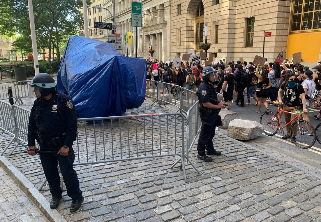 Police officers protect a covered up, barricaded Wall Street bull statue